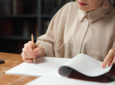 A hand writing a translated document by pen