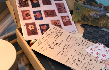 A box of hand-addressed letters and flower stamps